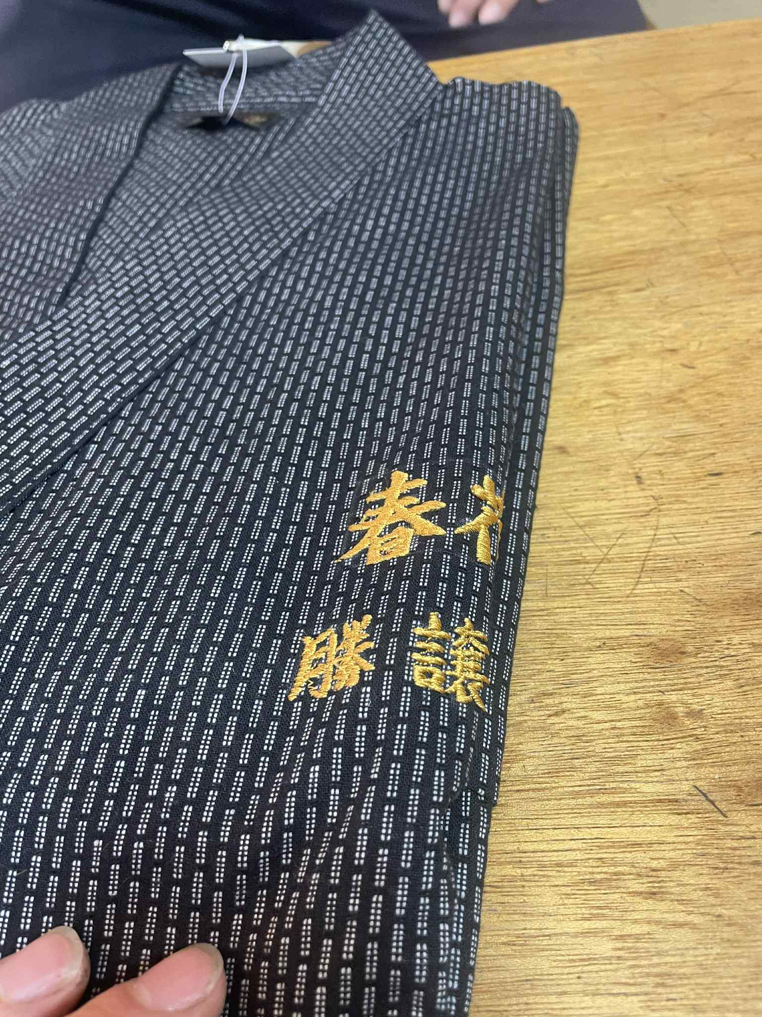 El kimono oficial con los cuatro kanji del nombre bordados en hilo dorado